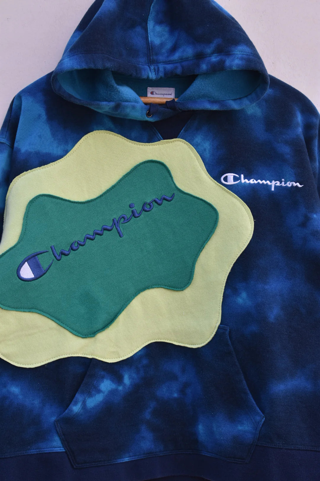 MEZOTER “Aqua Vibe” Champion Hoodie – Blue Tie-Dye Hoodie with Green Patch Design